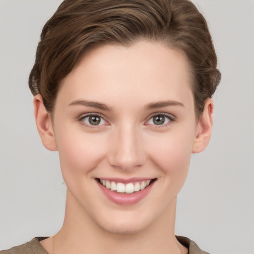 Joyful white young-adult female with short  brown hair and grey eyes