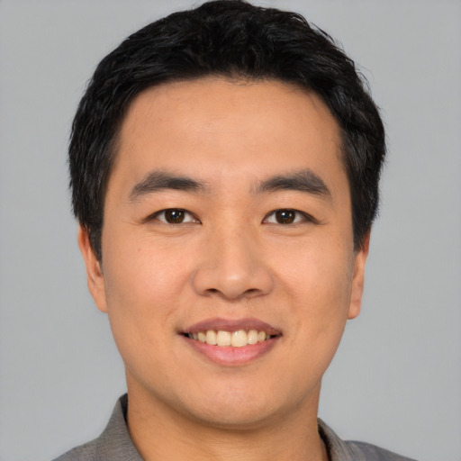 Joyful asian young-adult male with short  black hair and brown eyes