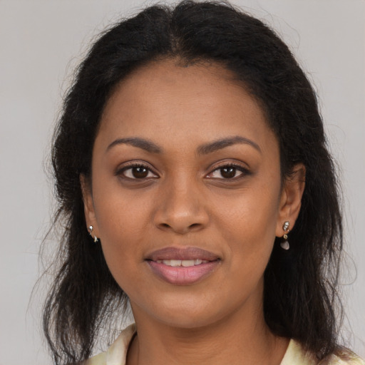 Joyful black young-adult female with long  brown hair and brown eyes