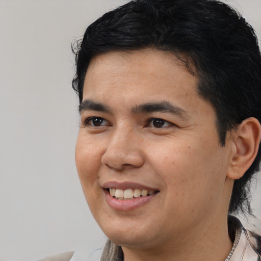 Joyful latino young-adult male with short  black hair and brown eyes