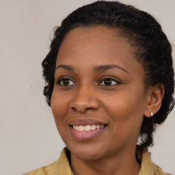 Joyful black young-adult female with medium  brown hair and brown eyes