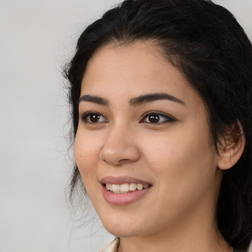 Joyful latino young-adult female with long  black hair and brown eyes