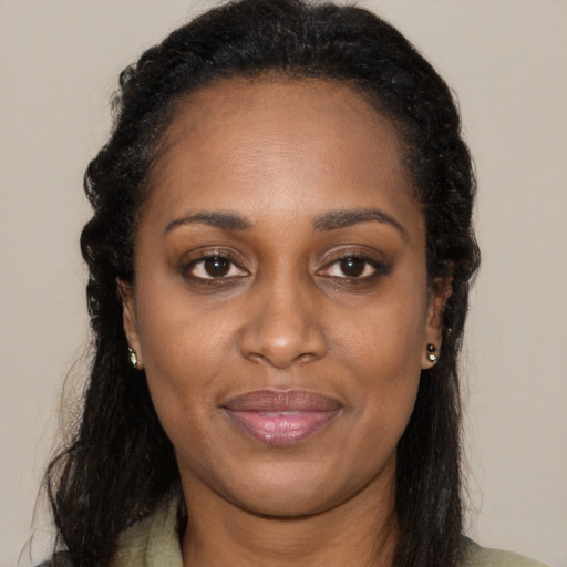 Joyful black young-adult female with long  brown hair and brown eyes