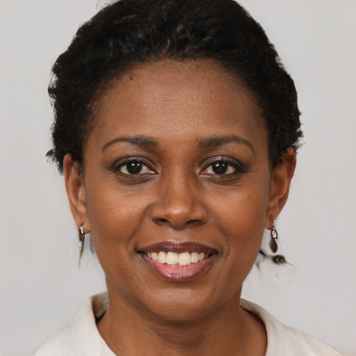 Joyful black young-adult female with short  black hair and brown eyes
