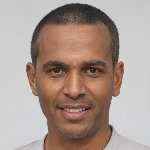 Joyful latino adult male with short  black hair and brown eyes