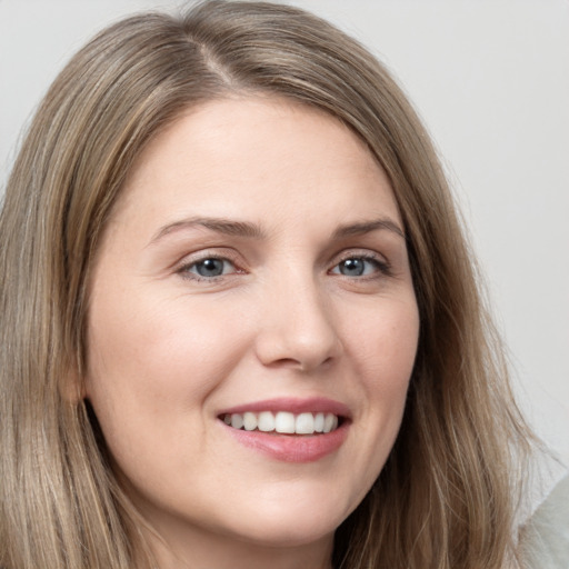 Joyful white young-adult female with long  brown hair and grey eyes