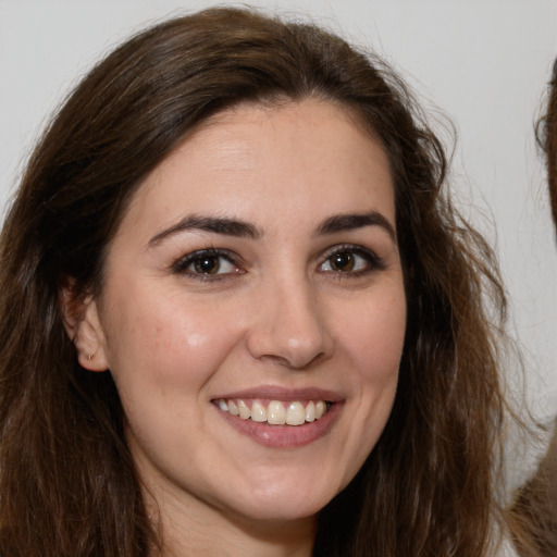 Joyful white young-adult female with long  brown hair and brown eyes