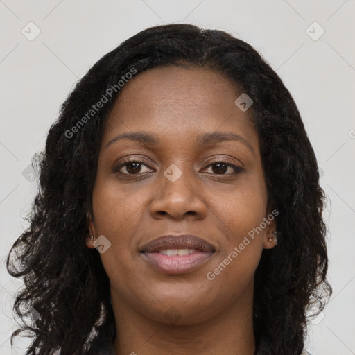 Joyful black young-adult female with long  black hair and brown eyes