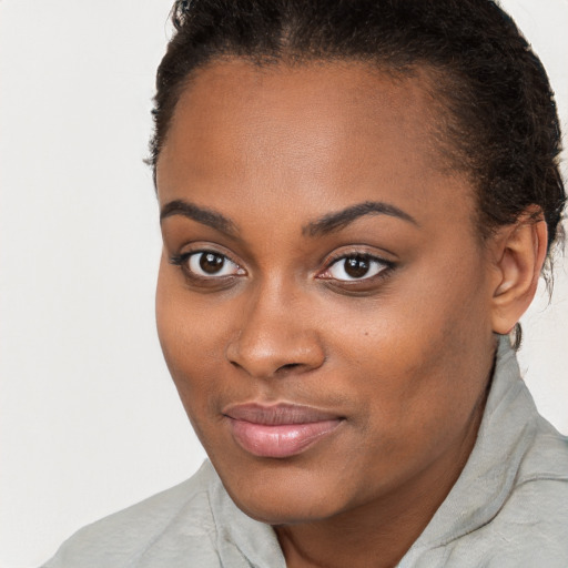 Joyful black young-adult female with short  brown hair and brown eyes