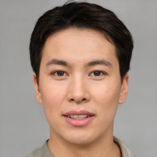 Joyful asian young-adult male with short  brown hair and brown eyes