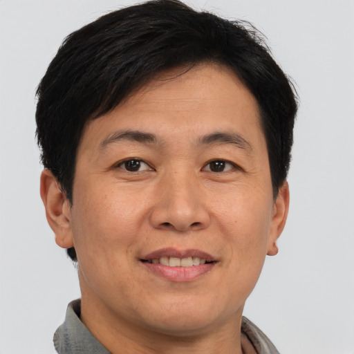 Joyful asian adult male with short  brown hair and brown eyes