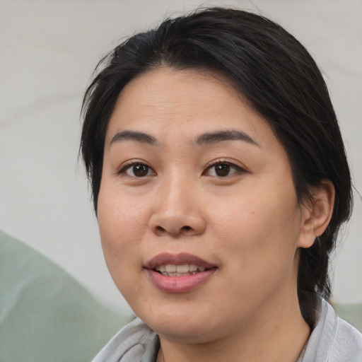 Joyful asian young-adult female with medium  brown hair and brown eyes