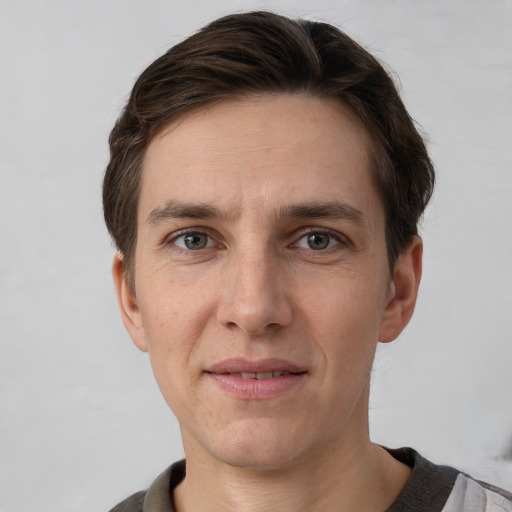 Joyful white adult male with short  brown hair and grey eyes