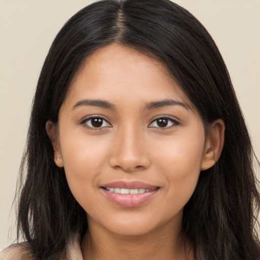 Joyful latino young-adult female with long  brown hair and brown eyes