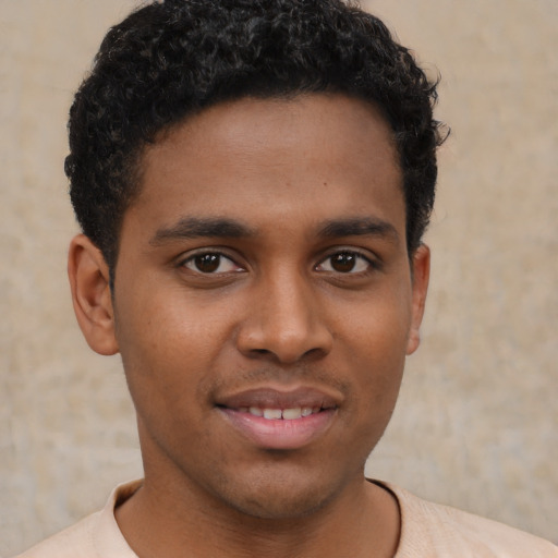 Joyful black young-adult male with short  brown hair and brown eyes