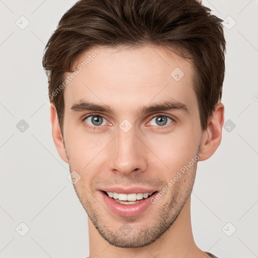 Joyful white young-adult male with short  brown hair and grey eyes