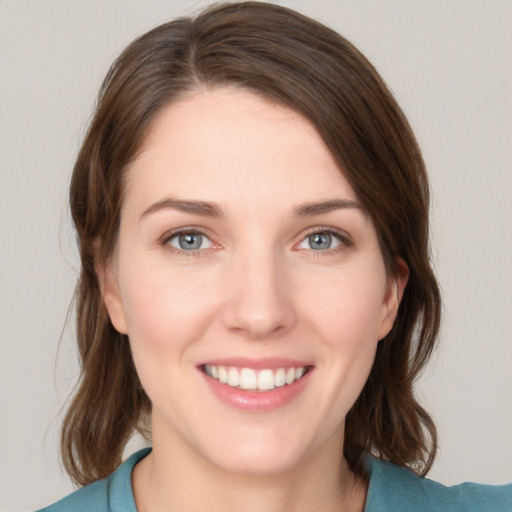 Joyful white young-adult female with medium  brown hair and grey eyes