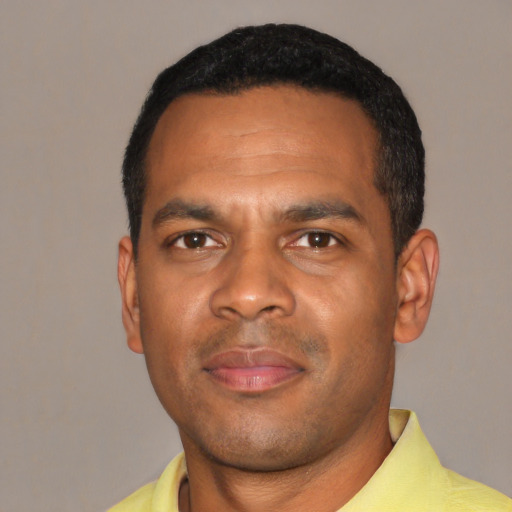 Joyful black young-adult male with short  black hair and brown eyes