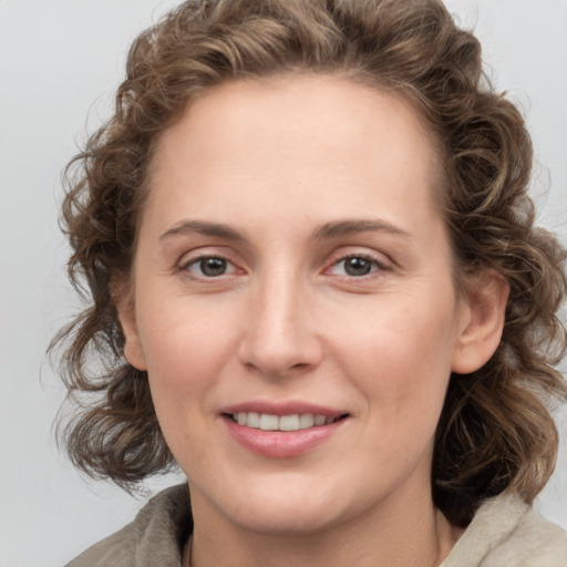 Joyful white young-adult female with medium  brown hair and blue eyes