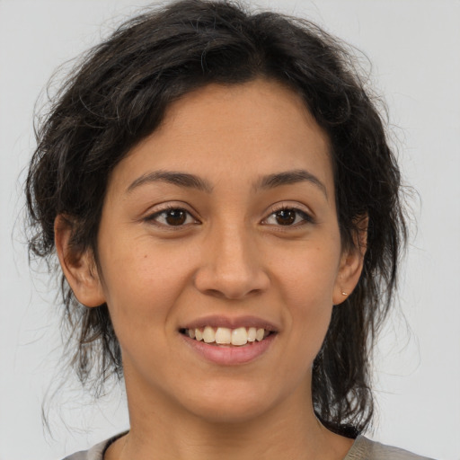 Joyful latino young-adult female with medium  brown hair and brown eyes