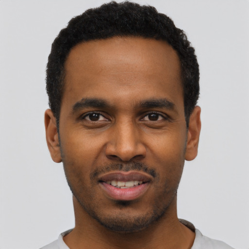 Joyful black young-adult male with short  black hair and brown eyes