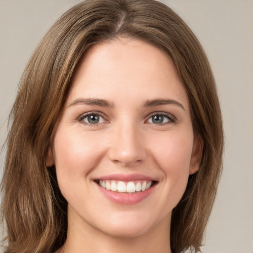 Joyful white young-adult female with long  brown hair and green eyes