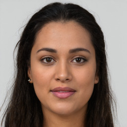 Joyful latino young-adult female with long  brown hair and brown eyes