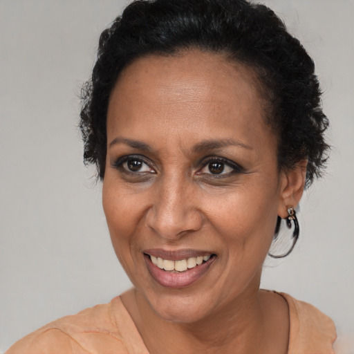 Joyful black adult female with short  brown hair and brown eyes
