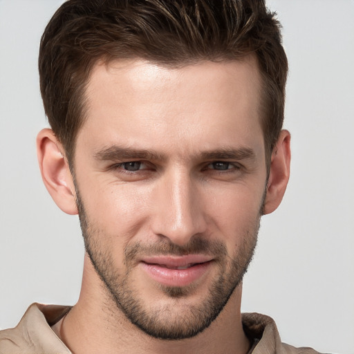 Joyful white young-adult male with short  brown hair and grey eyes