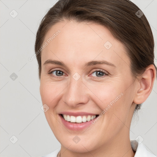 Joyful white young-adult female with medium  brown hair and grey eyes