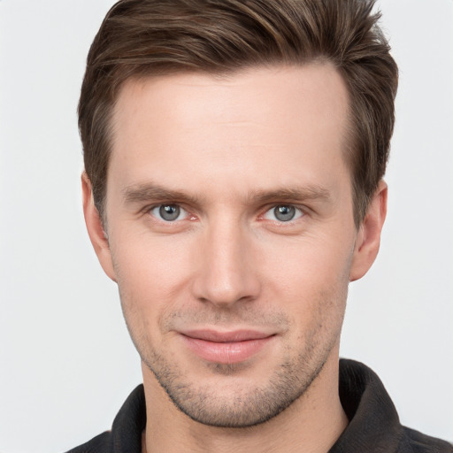 Joyful white young-adult male with short  brown hair and grey eyes