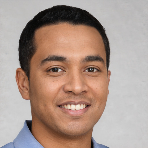 Joyful latino young-adult male with short  black hair and brown eyes