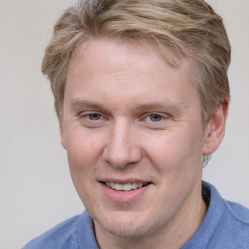 Joyful white adult male with short  brown hair and blue eyes