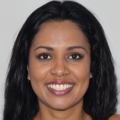 Joyful black young-adult female with long  black hair and brown eyes