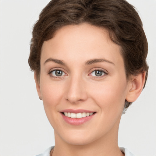 Joyful white young-adult female with short  brown hair and grey eyes