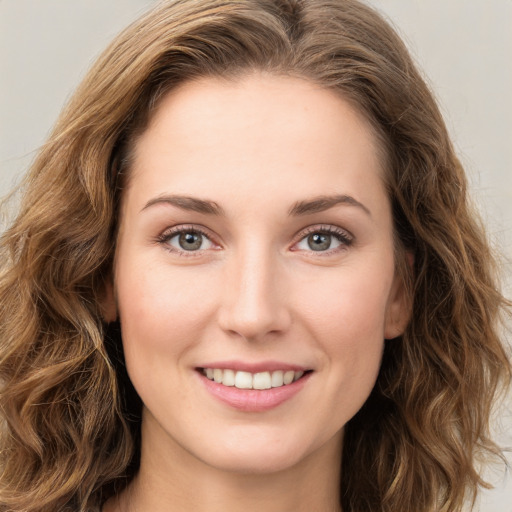 Joyful white young-adult female with long  brown hair and green eyes