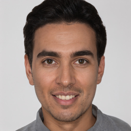 Joyful white young-adult male with short  black hair and brown eyes