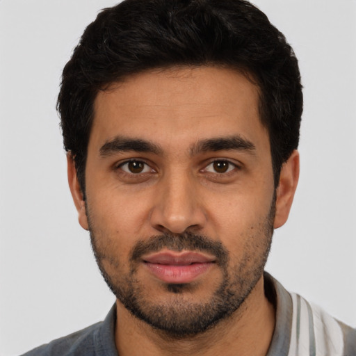 Joyful latino young-adult male with short  black hair and brown eyes