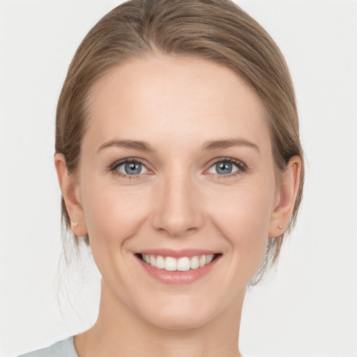 Joyful white young-adult female with medium  brown hair and grey eyes