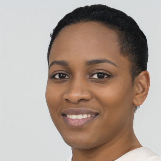 Joyful black young-adult female with short  black hair and brown eyes