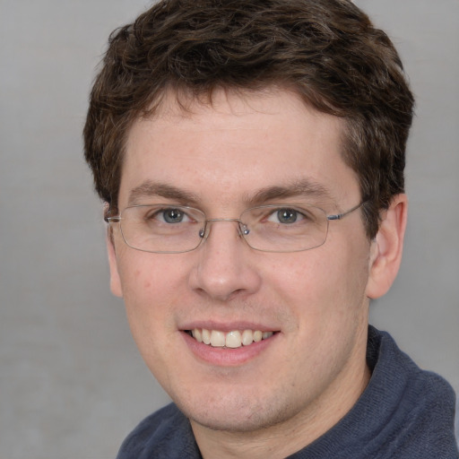 Joyful white adult male with short  brown hair and blue eyes