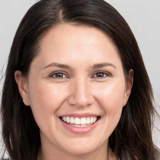 Joyful white young-adult female with long  brown hair and brown eyes