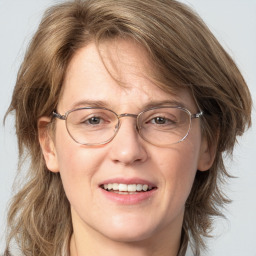 Joyful white adult female with medium  brown hair and grey eyes