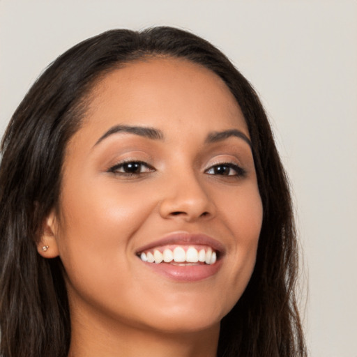 Joyful latino young-adult female with long  brown hair and brown eyes