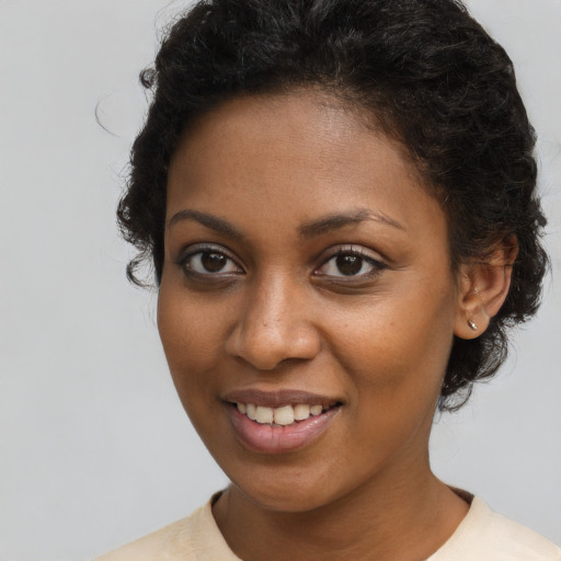 Joyful black young-adult female with short  brown hair and brown eyes
