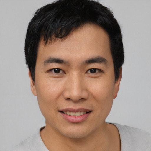 Joyful asian young-adult male with short  black hair and brown eyes