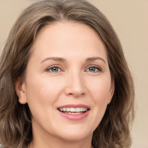 Joyful white young-adult female with medium  brown hair and green eyes