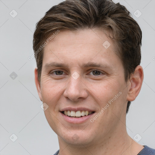 Joyful white young-adult male with short  brown hair and grey eyes