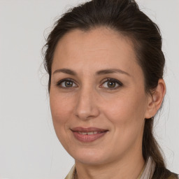 Joyful white adult female with long  brown hair and brown eyes