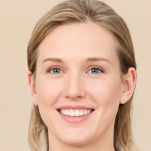 Joyful white young-adult female with long  brown hair and blue eyes